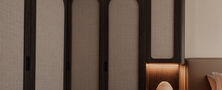 Master bedroom interior featuring custom dark wood arched headboard wall built-in nightstand and table lamp.
