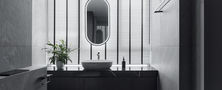 Modern master bathroom vanity featuring dark stone counter, undermount washbasin, oval backlit mirror, and vertical striped blinds.
