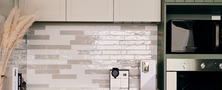 Modern kitchen design featuring sage green vertical fluted lower cabinets, off-white upper cupboards, and integrated ovens.