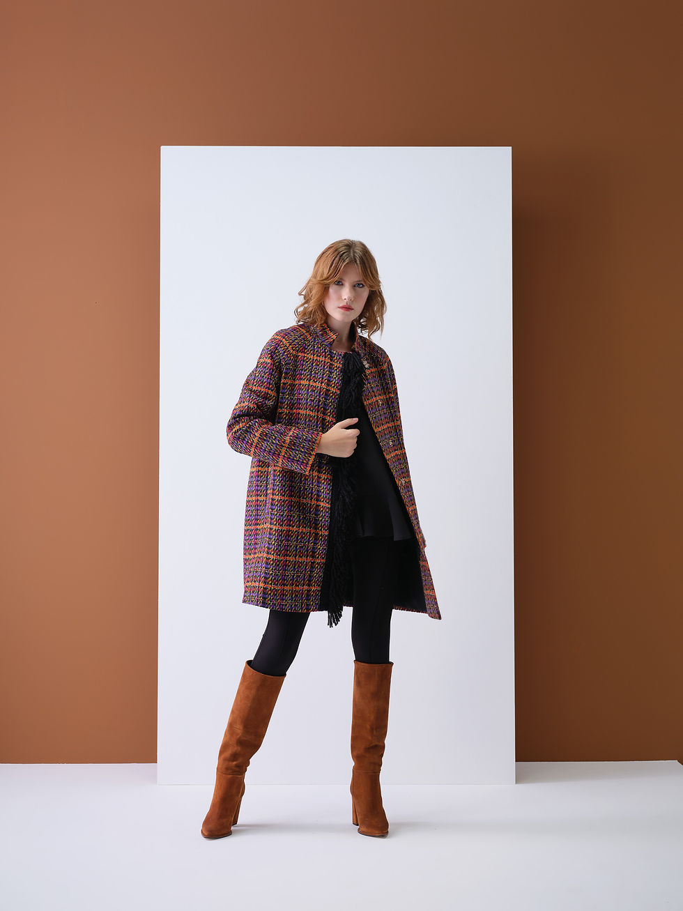 Mulher elegante vestindo casaco xadrez e botas.