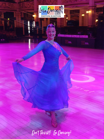 Woman posing in a blue ballroom dance dress