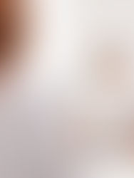 A man in a white shirt sits in a doctor's office facing a woman with red hair. The setting is bright with a white background.