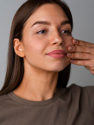 Woman gently touching her nasolabial folds at Juvenology Clinic, Maidstone, Kent.