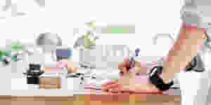 person at desk writing a list