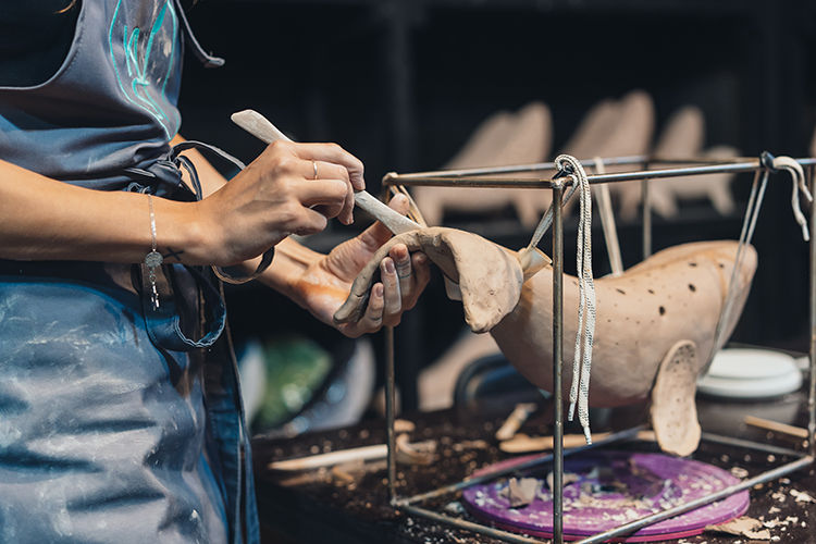portrait-young-woman-enjoying-favorite-job-workshop-potter-carefully-works-clay-whale.jpg