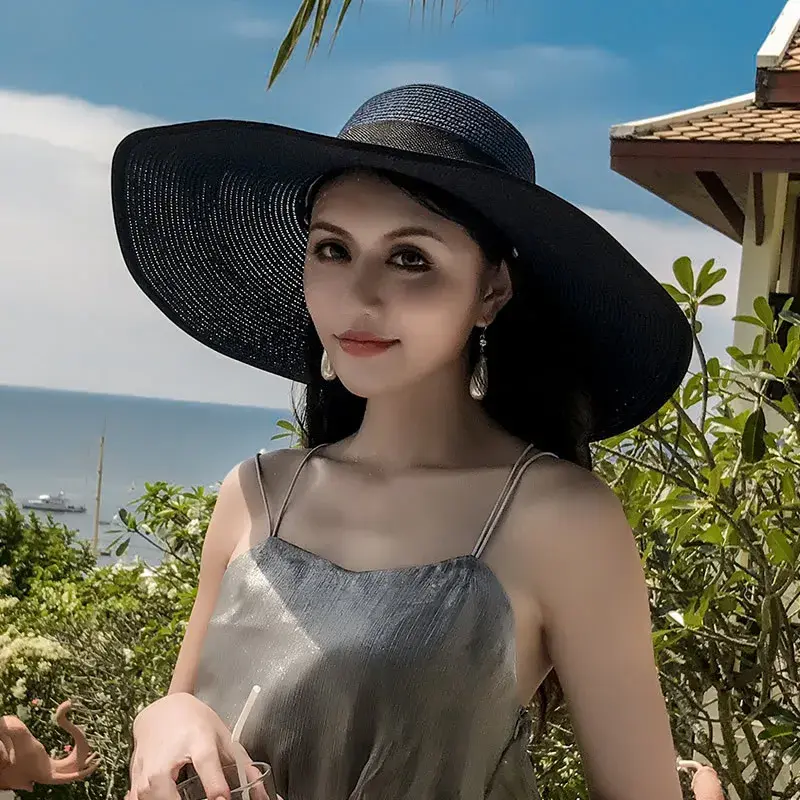 Miniatyrbilde: Woman wearing large black sun hat