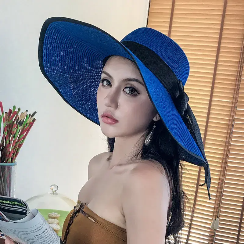 Miniatyrbilde: Woman wearing a large blue sun hat
