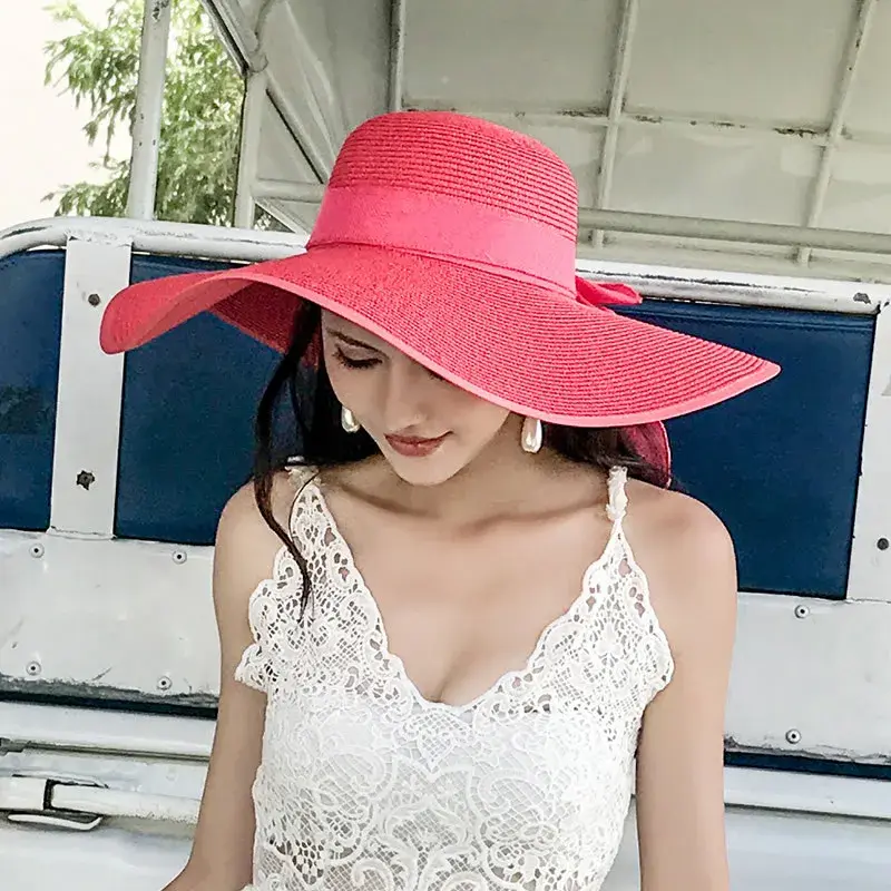 Miniatyrbilde: Woman wearing a large pink sun hat