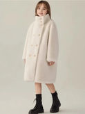 Young girl in a white coat standing. KMCee Style fashion for winter.