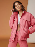Woman in pink jacket is modeling the latest fashion trends KMCee Style