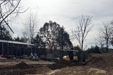Yellow bulldozer performing site preparation and leveling for a new pole barn foundation in Jefferson County, TN.