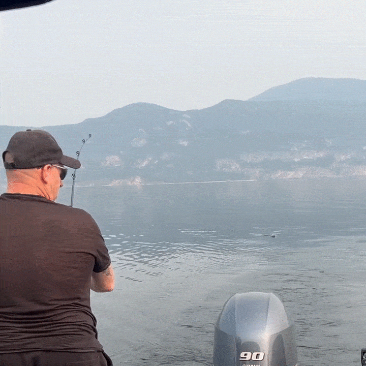 A man fishing off the back of a boat