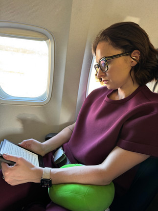 Tayste reading on plane with her Loop Earplugs
