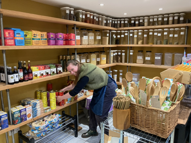 Magdalena ensuring the shelves are fully stocked