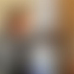 A man wearing ear defenders pouring coffee beans into a grinder