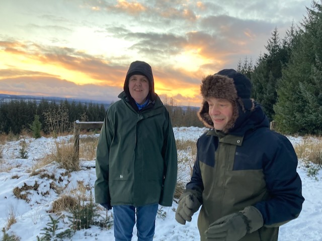 Two men enjoy winter sunset walk