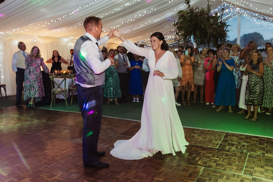bride and groom in first dance photo in their Hampshire garden DIY marquee wedding