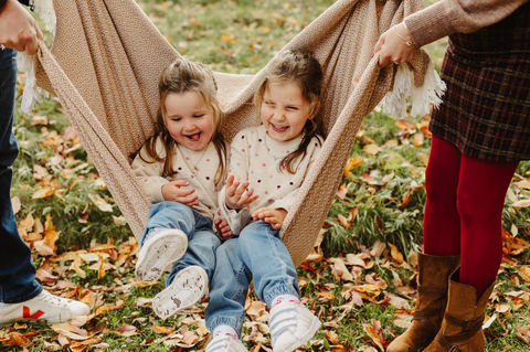 2 sisters get swung in blanket in the autumn leaves