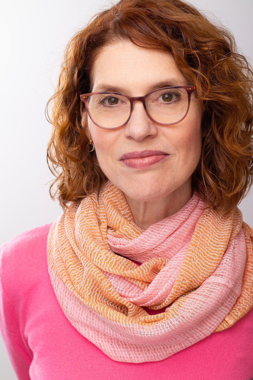 colorful headshot of woman in glasses and bright pink shirt