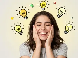 A smiling woman, hands on her face, has several lit light bulbs drawn around her head, symbolising the awakening of new ideas and creativity in the state of eustress.