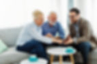 Senior couple having a meeting with an agent, businessman, salesperson or doctor in his of