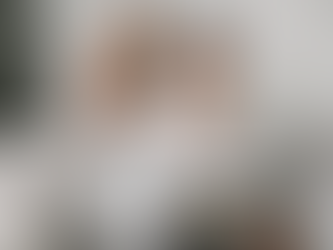 A mature couple sits together on a couch, reviewing their finances on a laptop to plan their future together.