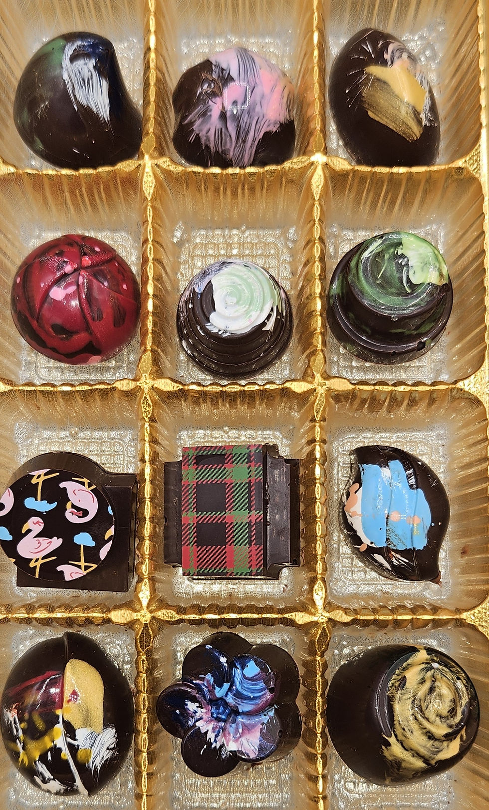 12 pieces of colorful chocolate in a gold tray