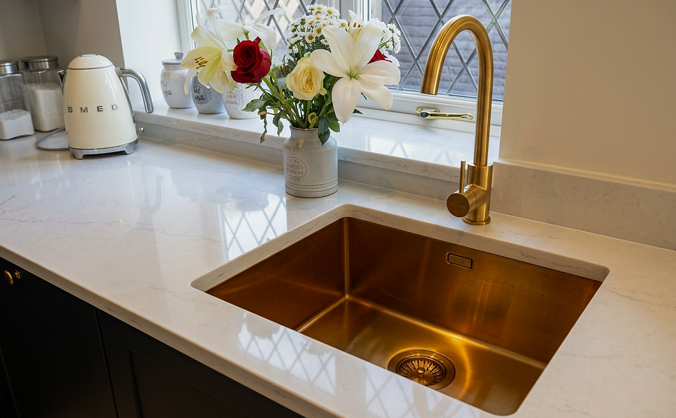 Modern kitchen sink with gold faucet and white countertop