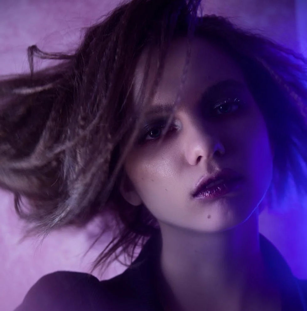 A young woman with crimped hair on a purple background