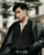 young man in black button down and black leather jacket with a cross necklace