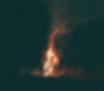 A campfire with sparks rising into a night sky