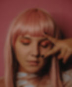 a woman with light pink hair on a pink background