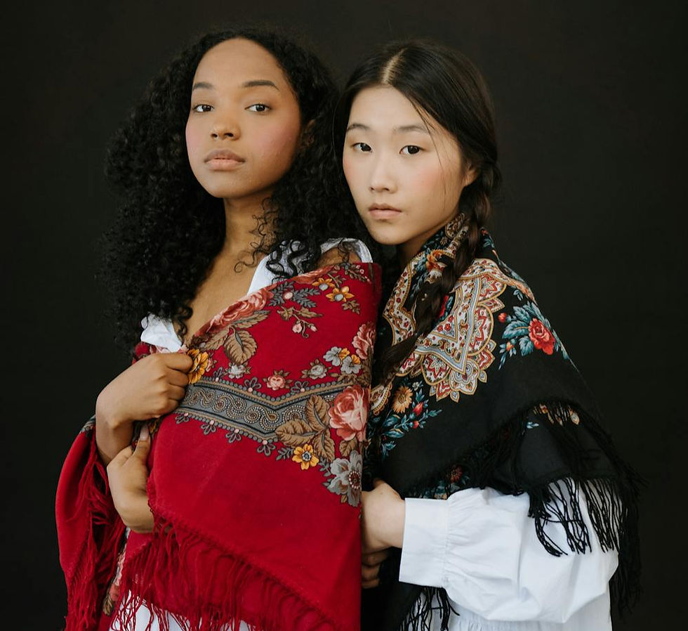 two female models in white blouses wearing colorful shawls over their shoulders.