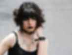 woman with a black bob and black lipstick wearing a black choker and silver necklaces