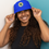 Thumbnail: woman wearing royal blue bucket hat with oslt logo