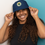 Thumbnail: woman wearing navy bucket hat with oslt logo