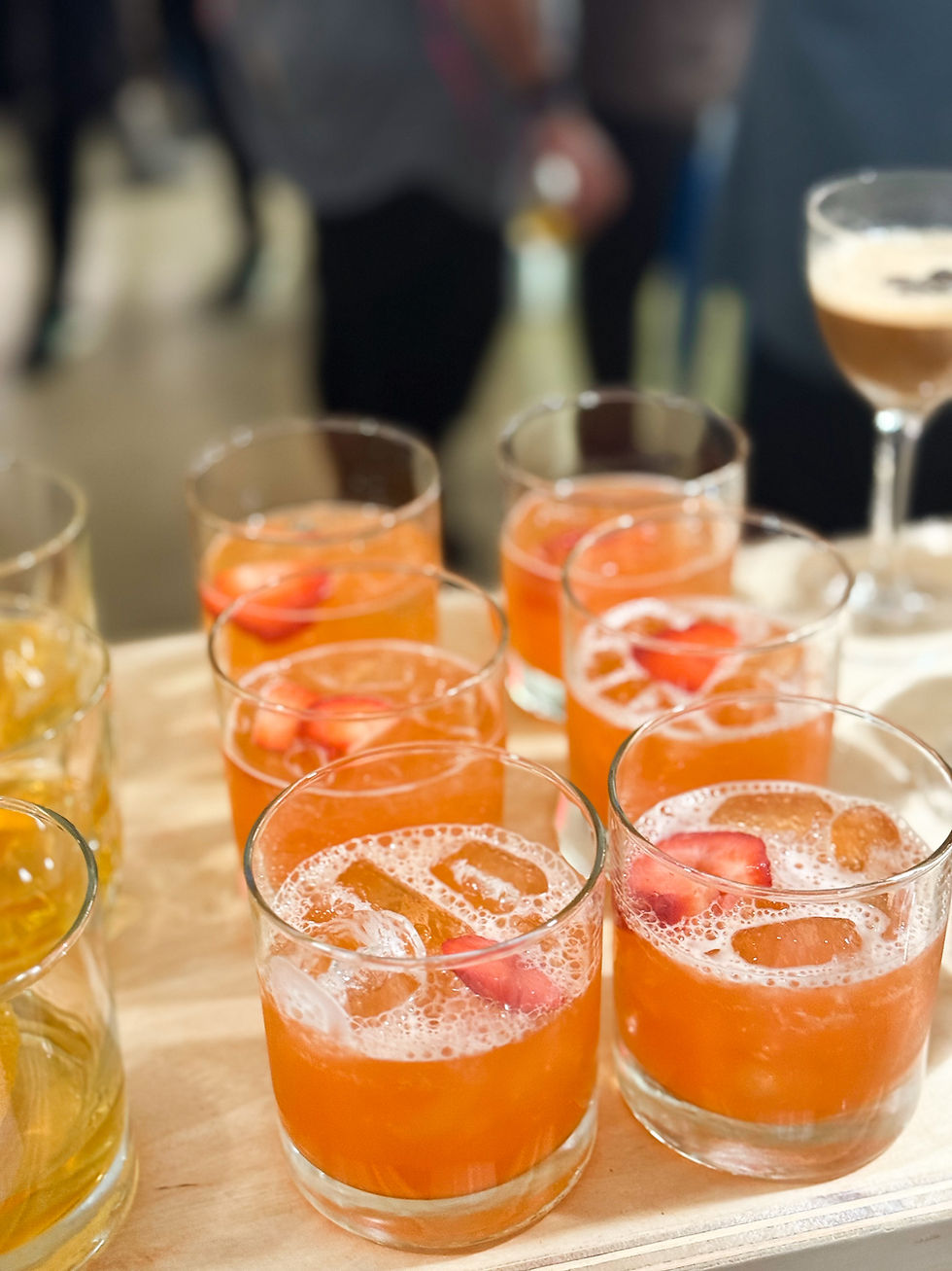 Close-up view of a bartender pouring a colorful cocktail at a mobile bar