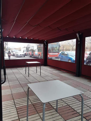 INTERIOR DE PÉRGOLA CON TOLDOS CORTAVIENTOS COMPLETAMENTE CERRADA PARA USO EN CUALQUIER ESTACIÓN CON ROTULACIÓN EN COLGANTES