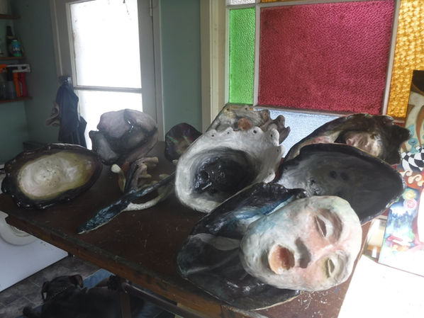 Interior surfaces of the handmade sculptural heads during the first stages of oil painting, showing the curved three-dimensional canvases.