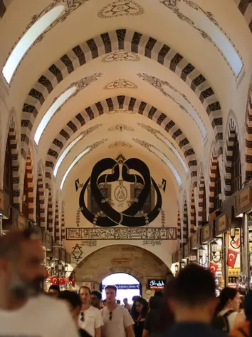 The bustling central corridor of the Spice Bazaar featuring traditional shops and arches. A historic shopping experience conveniently near Casa Rosa Suites.