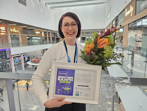 Tia Nyman Baronalta seisoo Triplan ostoskeskuksessa hymyillen kukkien ja Frendien vuoden 2025 sertifikaatin kanssa