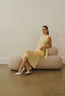 Model Lorena Nicoleta posing in a sophisticated, elegant salon wearing a tailored pale yellow suit jacket and matching trousers.