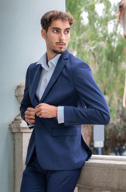 Sergio Camacho, 1.90m male model in a sharp blue suit and light blue shirt, posing outdoors. Elegant commercial menswear portfolio by Salitre Models.