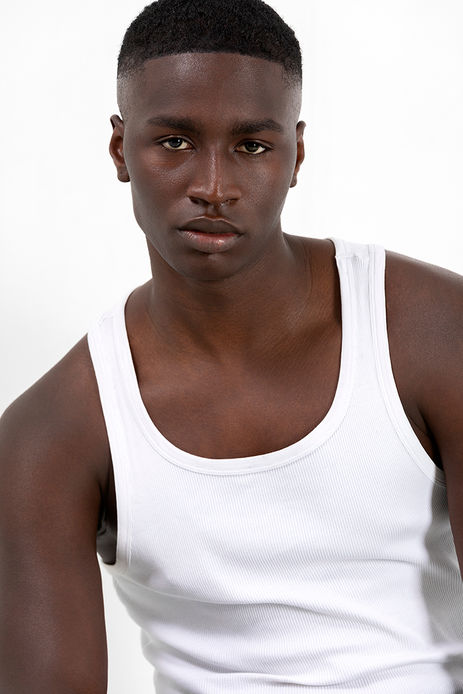 Omar Diop wearing a basic white tank top in a minimalist studio photoshoot – Male model portfolio for Salitre Models.