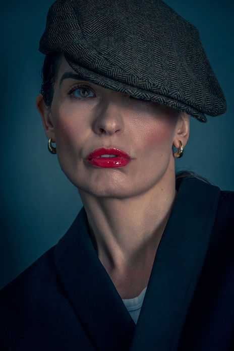 Commercial model Gosia Laskowska posing in studio wearing an El Ganso beret, Ray-Ban aviator sunglasses, a navy blue blazer, and vibrant red lipstick.