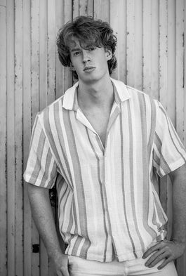 Candid outdoor photograph of redhair male model Nelson Del Toro, capturing a natural, relaxed expression that highlights his authentic personality.