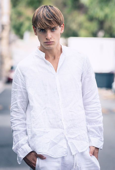Leonardo Russo new face male model all-white resort wear look linen shirt tailored Bermuda shorts sneakers outdoor summer shoot Salitre Models