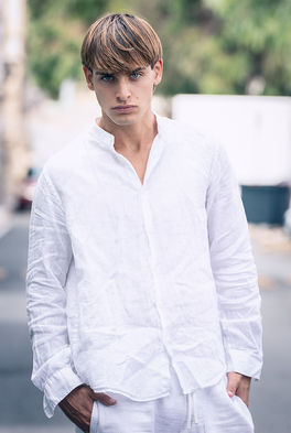 Leonardo Russo new face male model all-white resort wear look linen shirt tailored Bermuda shorts sneakers outdoor summer shoot Salitre Models