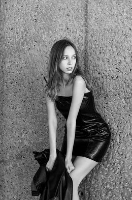 Ester Diaz new face model Canary Islands posing outdoors in short leather dress holding jacket Salitre Models
