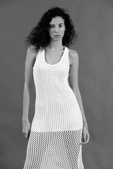 High-fashion black and white studio photograph of model Mireya Garcia wearing an editorial mesh outfit, highlighting strong lighting contrasts and artistic textures.